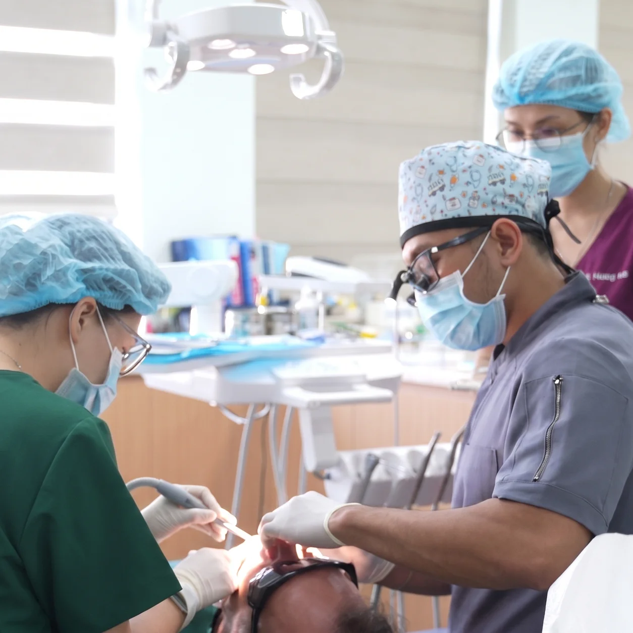 Bác sĩ và trợ thủ nha khoa thực hiện phẫu thuật răng hàm mặt chuẩn y khoa